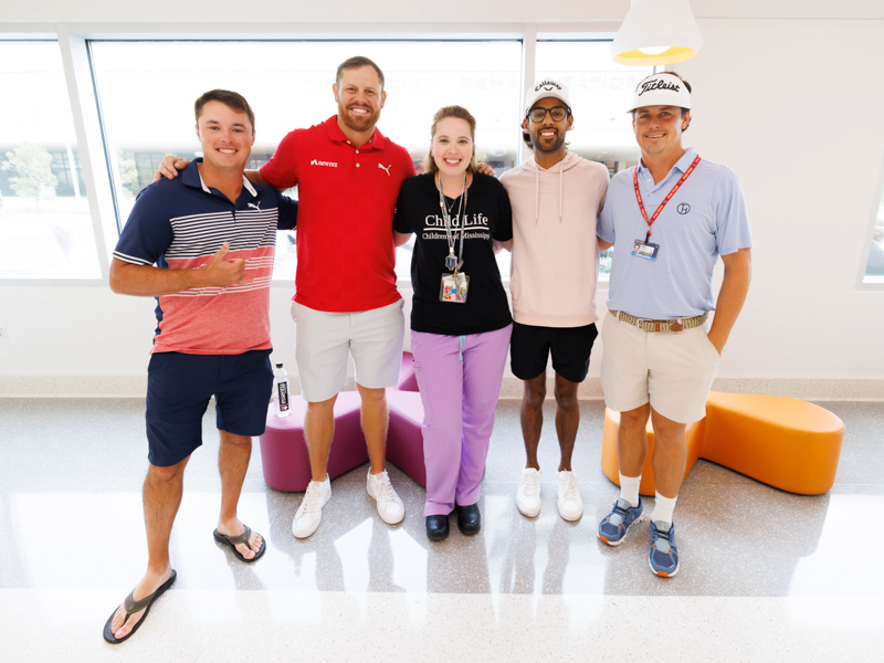 Children's of Mississippi child life specialist Madeline Wilson smiles with Sanderson Farms Championship golfers, from left, Brent Grant, Kyle Westmoreland, Akshay Bhatia and Cody Gribble. Melanie Thortis/UMMC Photography